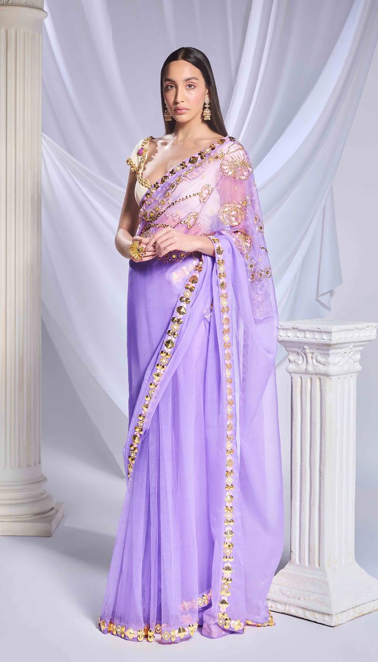 Introducing our lilac saree, crafted from a blend of tulle and organza fabrics. It features a dainty embroidered organza pallu adorned with intricate floral motifs made of sequins, metallic leaves, and cut dana. The pre-stitched tulle bottom features a refined gold border and acrylic motifs running along the hem. Paired with an ivory georgette blouse, embellished with metal circles, pearl embroidery, and delicate cutwork detailing throughout.From Papa Don’t Preach’s Bring Your Own Fairytale coll Lilac Saree, Pearl Embroidery, Love Potion, Georgette Blouse, Embroidered Organza, Gold Border, Organza Fabric, Floral Motifs, Cut Work