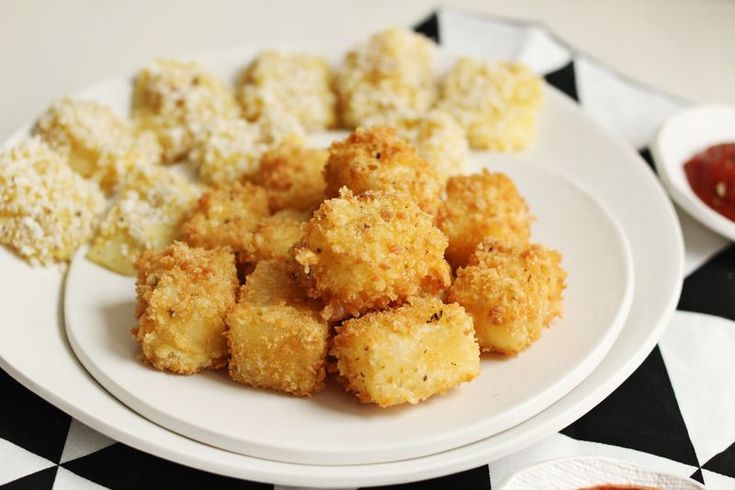 a plate full of tater tots with ketchup on the side