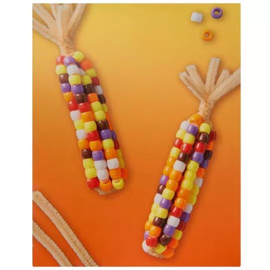 two corn on the cob made out of candy sticks and string with beads attached to them