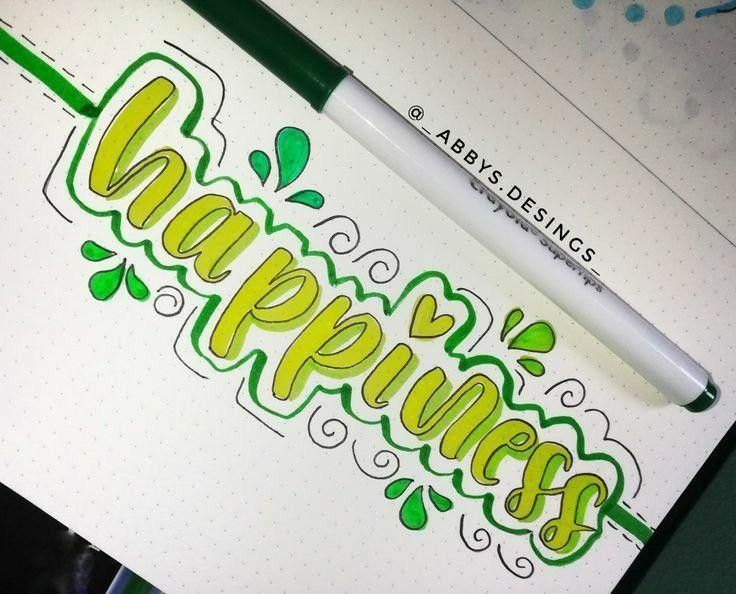 a pen sitting on top of a piece of paper with the word happiness written in green