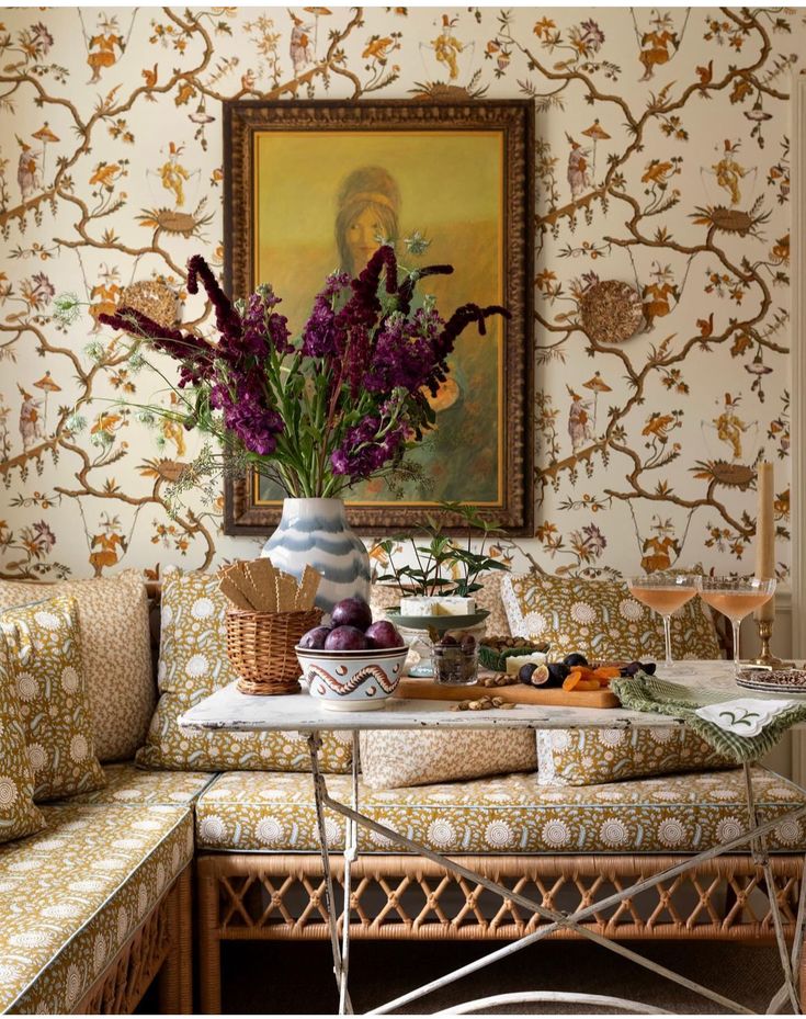 a vase filled with purple flowers sitting on top of a table next to a couch