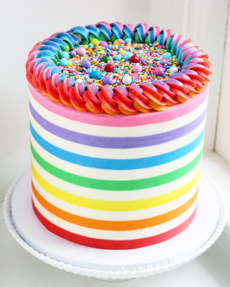 a rainbow colored cake with sprinkles on top