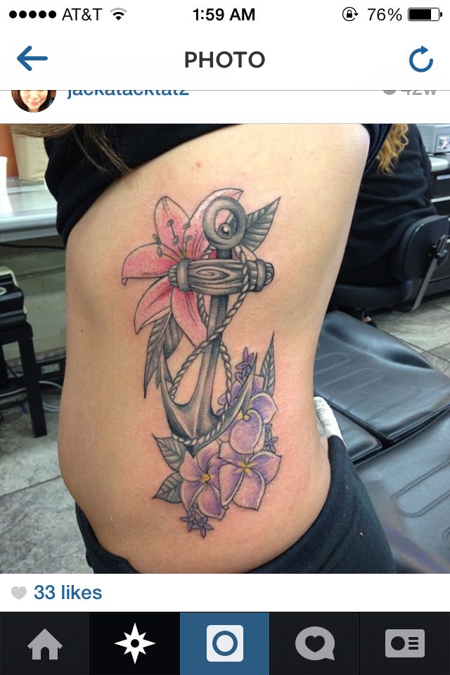 a woman's stomach with an anchor and flowers on it