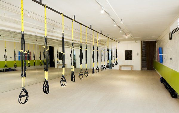 an empty gym with rows of exercise equipment hanging from the ceiling and on the wall