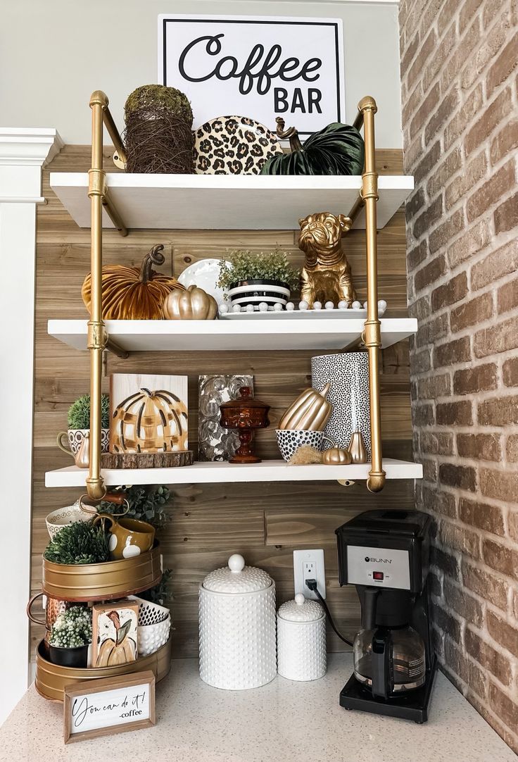 the coffee bar is decorated with gold and white decor, such as pumpkins, gourds, and more