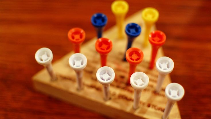 several toothbrushes are lined up on a wooden board with holes in the middle