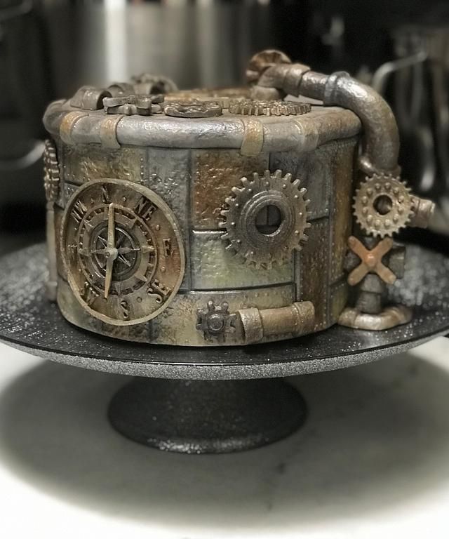 there is a cake made to look like a steampunky box on top of a plate