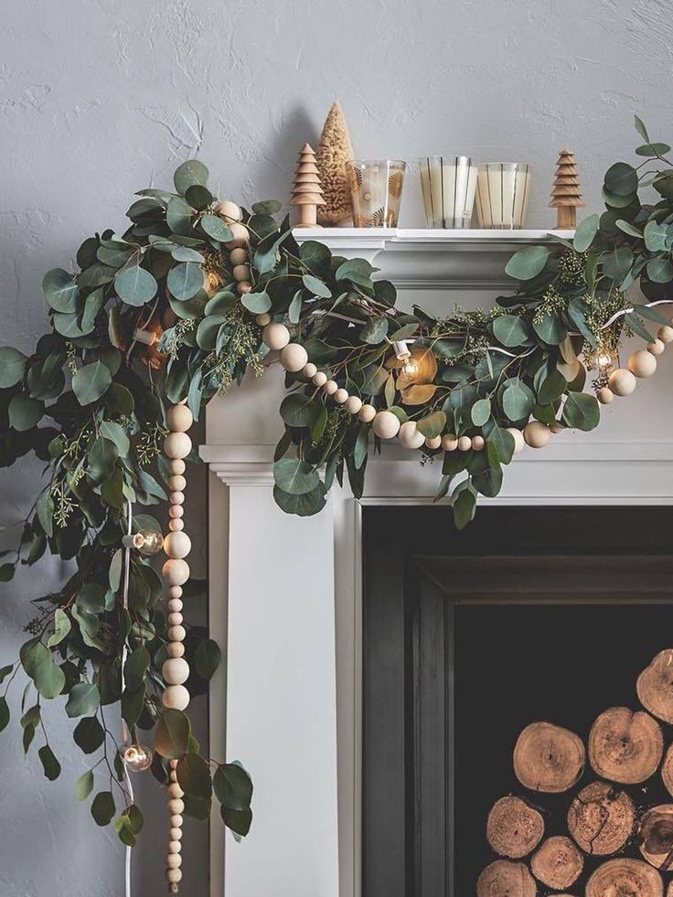 a fireplace decorated with greenery, candles and wood slices for christmas time decorating