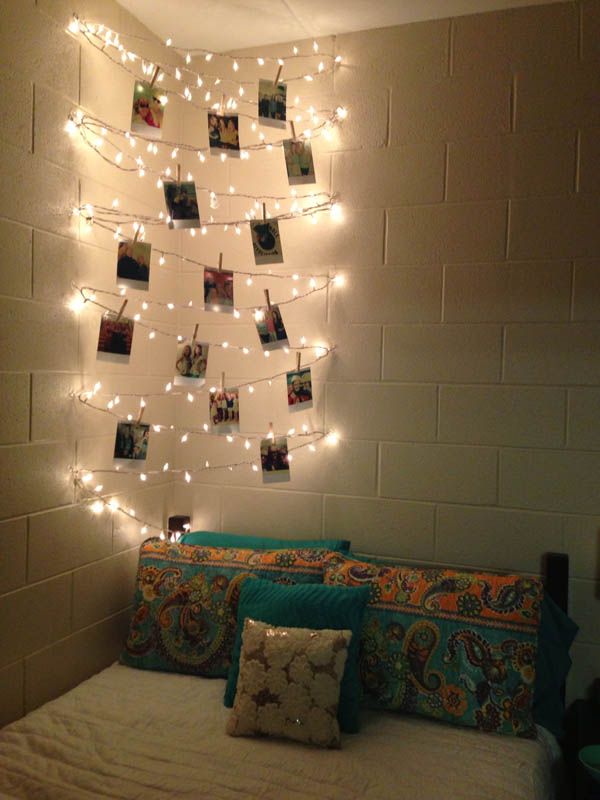 a bedroom with lights strung over the headboard and pillows on top of the bed