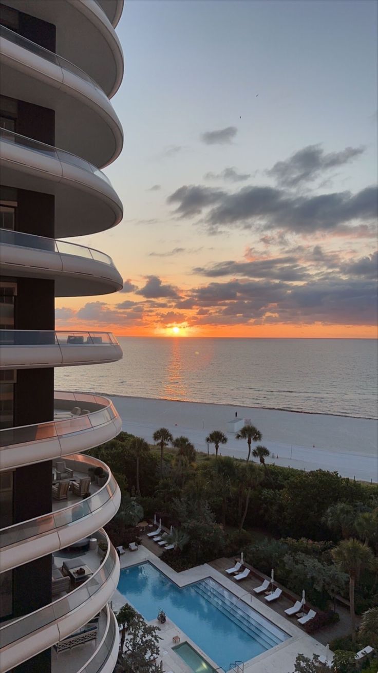 the sun is setting over an oceanfront pool and beach side condos in miami, florida