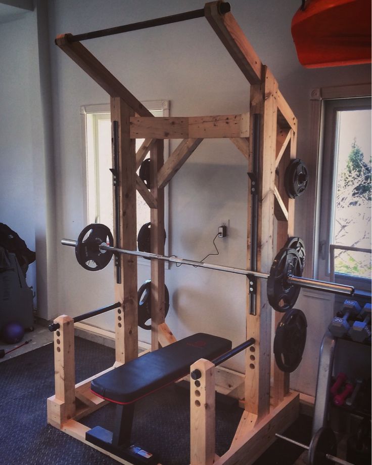 a home gym with bench, barbells and weight plates