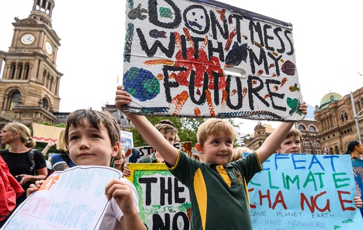 two young boys holding up signs in front of a building that says don't mess with my future