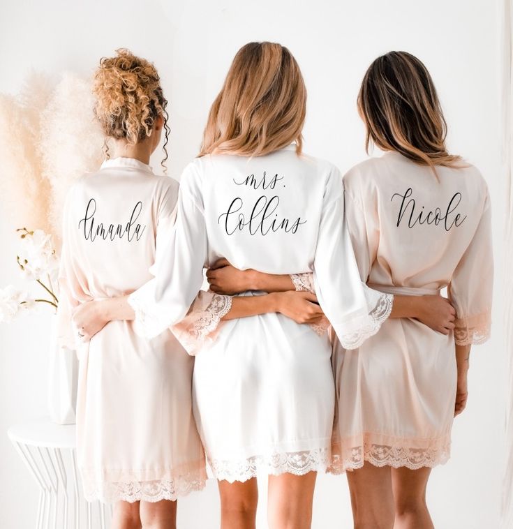 three bridesmaids in robes with their names on them