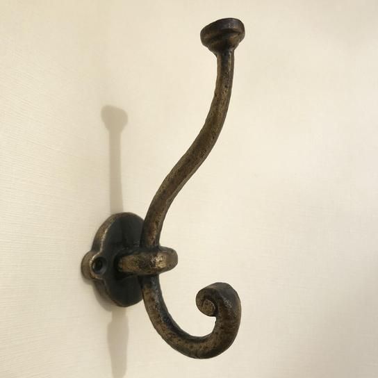 an iron hook on the wall with a white background