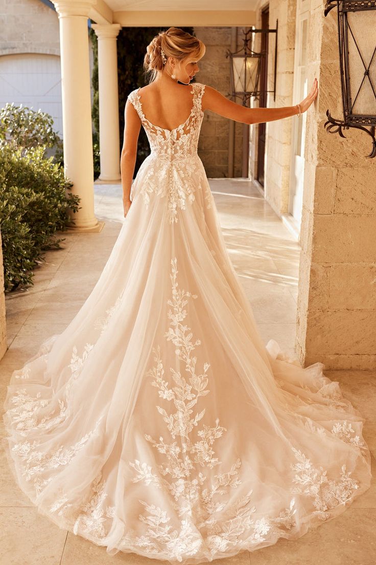 a woman in a wedding dress is walking through an archway with her back to the camera