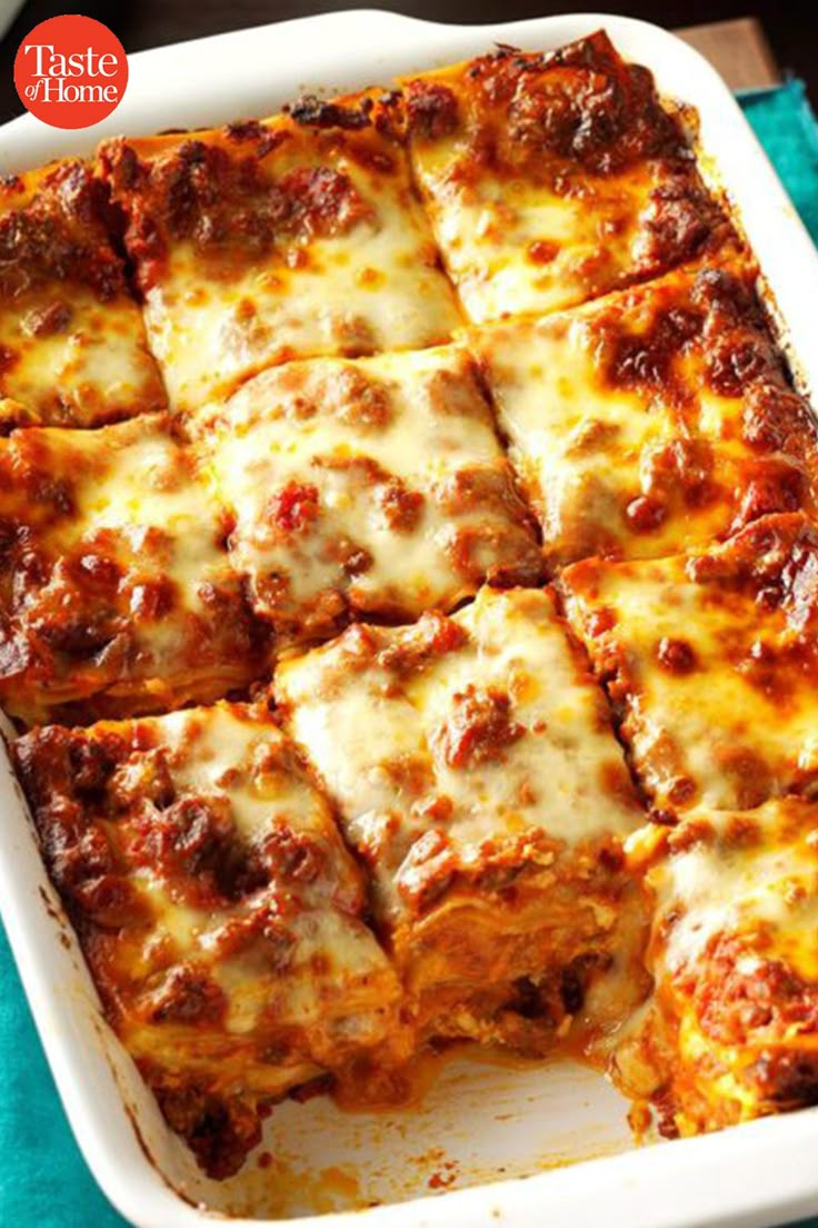 lasagna casserole with meat and cheese in a white dish on a blue towel