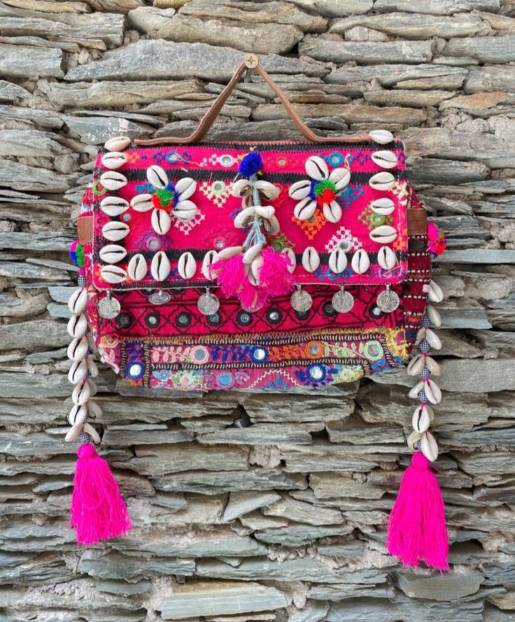 About bag  Indo-gypsy fusion, everyday use hand bag made from Banjara fabrics sourced from Vintage tribal costumes of regions of Rajastan and Gujarat. These are embellished with light catching coins, and intricate bead work tassels. Size - length 15 inches/ width 21 inches Company details:  Company name: Houseoftextile  Contact number: +919784447473  Email id: houseoftextile77@gmail.com  Shipping & custom : Delivery through one of the finest service providers : Skyway, Fedex, UPS  And DHL. Any l Pink Bohemian Bags For Festive Occasions, Festive Bohemian Pink Bag, Handmade Pink Shoulder Bag For Festivals, Bohemian Pink Satchel Bag, Bohemian Pink Embroidered Shoulder Bag, Pink Embroidered Bohemian Shoulder Bag, Pink Bohemian Embroidered Shoulder Bag, Bohemian Pink Bag For Festivals, Navratri Bohemian Potli Bag With Handwork