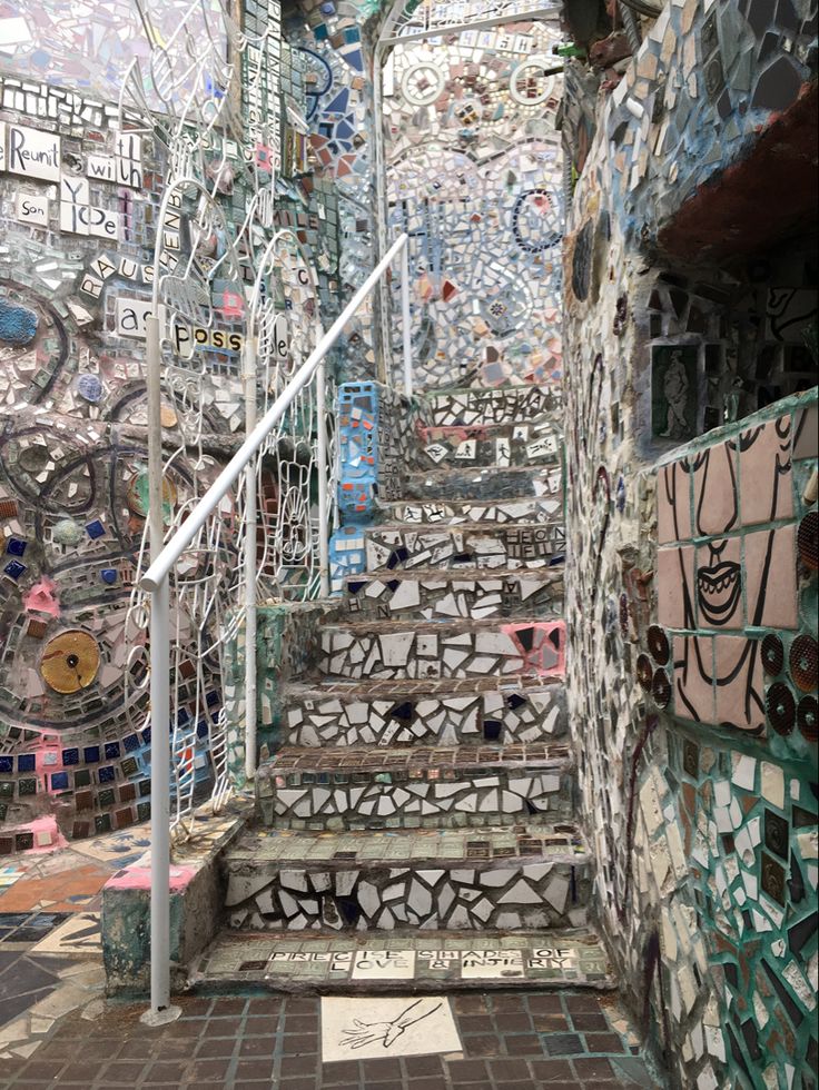 a set of stairs made out of mosaic tiles and metal railings with writing on them