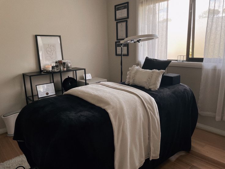 a black and white bed in a bedroom next to a window