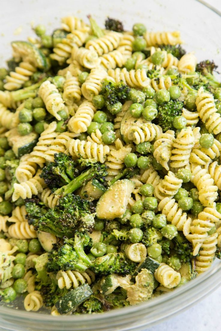 a glass bowl filled with pasta and broccoli