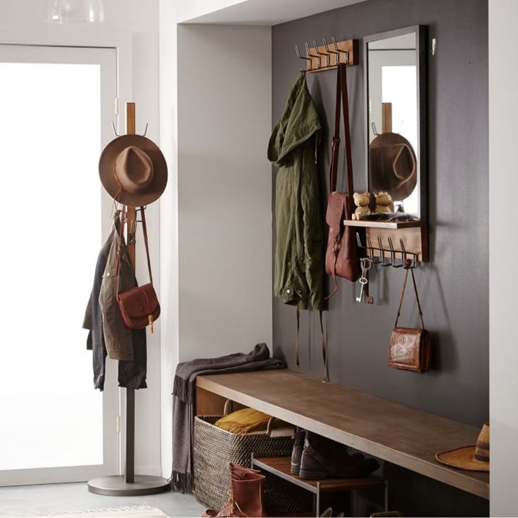 a coat rack with hats and purses hanging from it's hooks next to a door