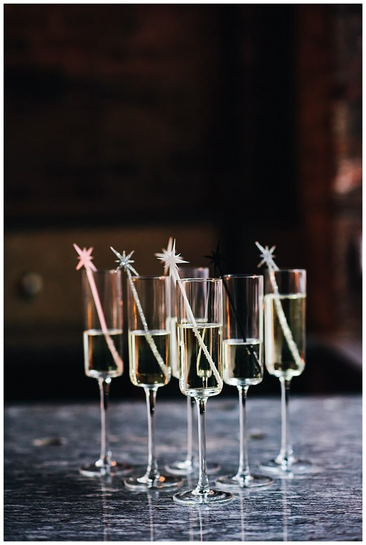 five glasses filled with champagne sitting on top of a table