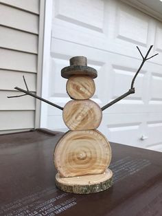 a snowman made out of wood sitting on top of a table