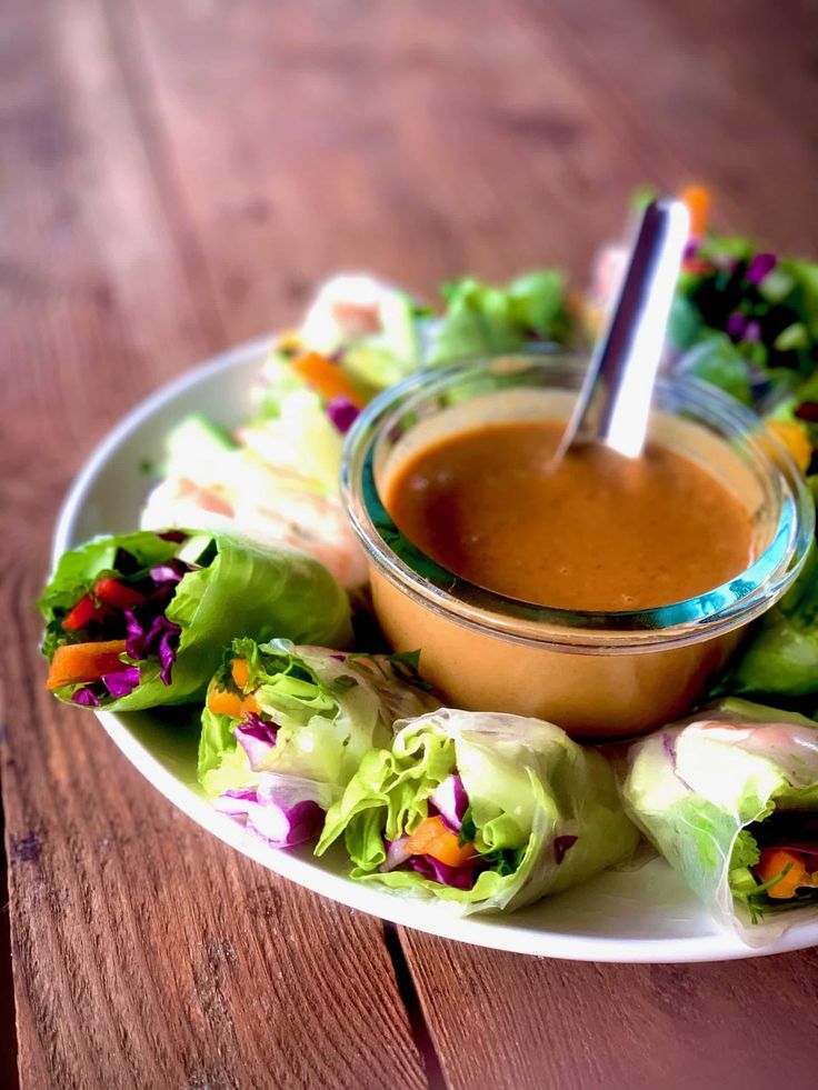 a white plate topped with lettuce and dipping sauce