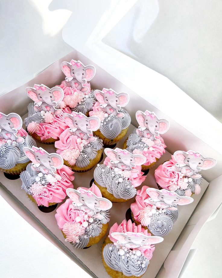 cupcakes with pink and silver decorations in a box