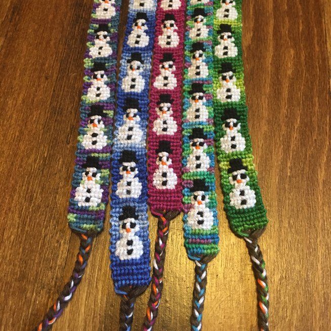 three snowman lanyards on top of a wooden table