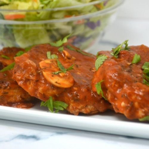 a white plate topped with meat covered in sauce