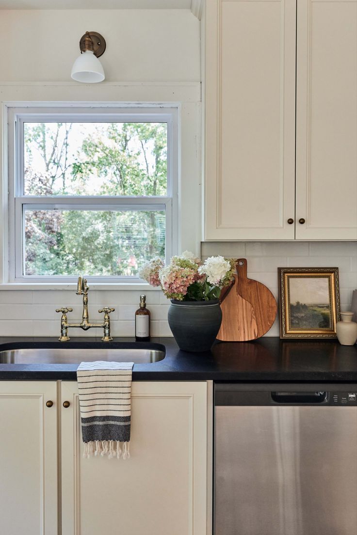 a kitchen with a sink, dishwasher and window in the backround