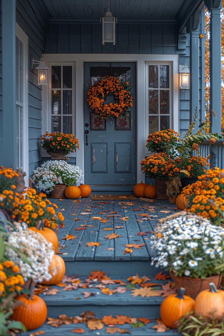 a front porch with pumpkins and flowers on the steps