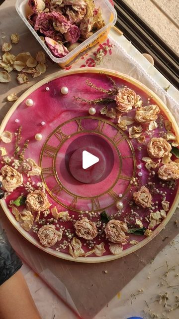 a table topped with a pink cake covered in flowers