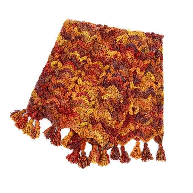 an orange and yellow blanket with tassels on it's edges, against a white background