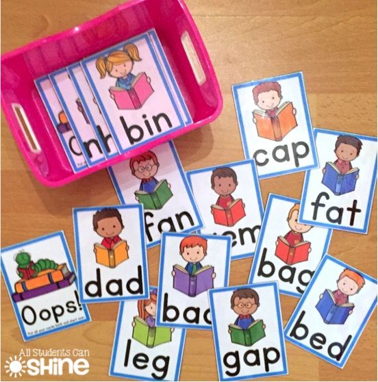 some cards with words and pictures on them sitting next to a pink container filled with children's books