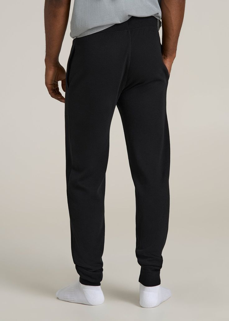 Upgrade Your Loungewear Game Tall Men's Jogger Pants That Fit Just Right Take your loungewear to the next level with our Waffle-Knit Lounge Jogger for tall men. These extra-long men's joggers offer a regular fit with a mid-rise that sits comfortably, and the drawstring waist ensures a secure fit. Side seam pockets add practicality to this essential home wear piece. Perfect for relaxing at home or running errands, these tall joggers combine comfort and functionality tailored for your taller frame Black Activewear With Ribbed Waistband And Tapered Leg, Black Tapered Leg Activewear With Ribbed Waistband, Black Cotton Comfort Stretch Sweatpants, Black Stretch Joggers For Lounging, Comfortable Black Pants With Comfort Waistband, Black Comfort Stretch Full Length Sweatpants, Black Sweatpants With Ribbed Waistband For Lounging, Black Joggers With Pockets For Lounging, Relaxed Fit Black Bottoms For Lounging