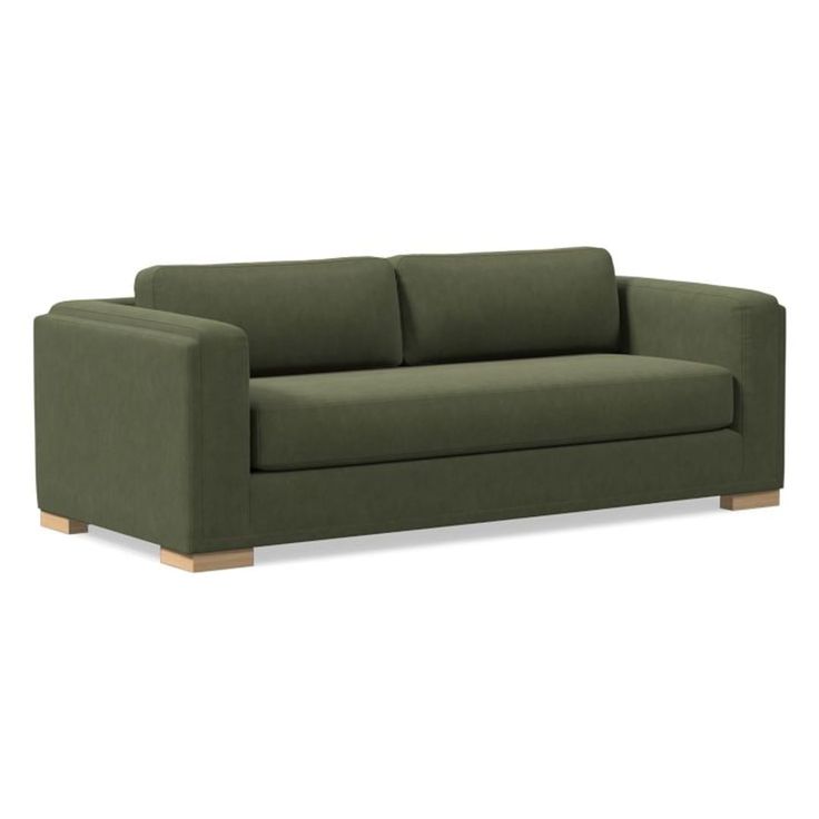 a green couch sitting on top of a white floor