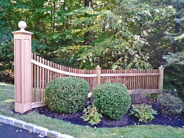 a wooden fence surrounded by bushes and trees