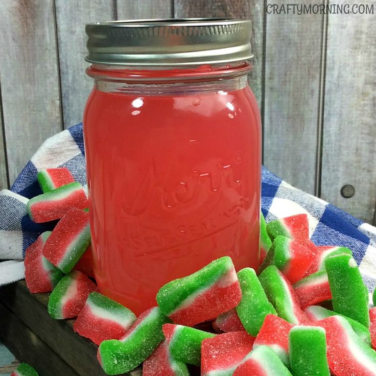 a jar filled with watermelon and marshmallows on top of a table