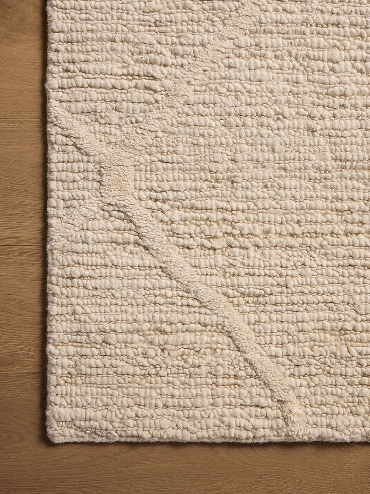 a white rug on top of a wooden floor