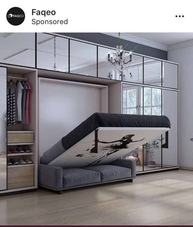 an open closet with a bed, mirror and chandelier hanging from the ceiling