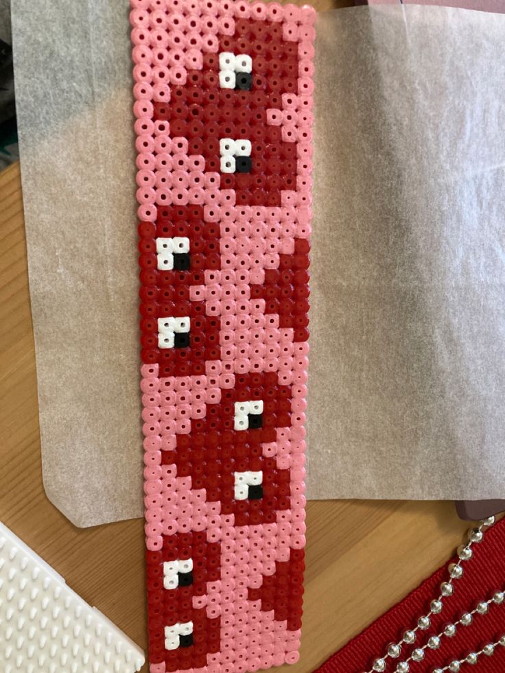 a pink and red beaded tie sitting on top of a table