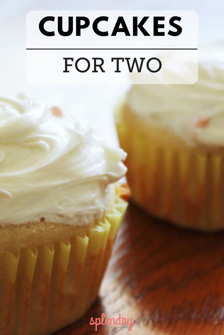 two cupcakes sitting on top of a wooden table