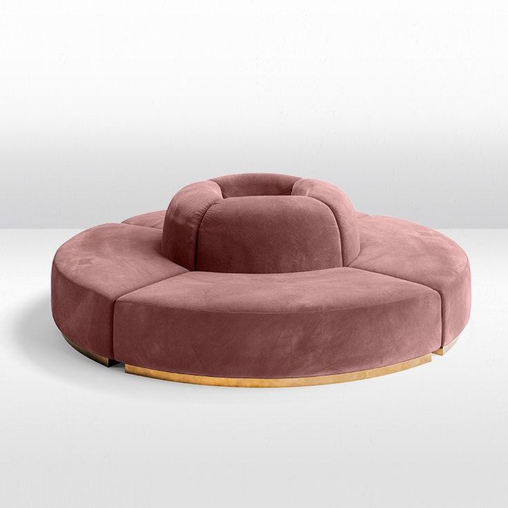 a pink circular couch sitting on top of a white floor