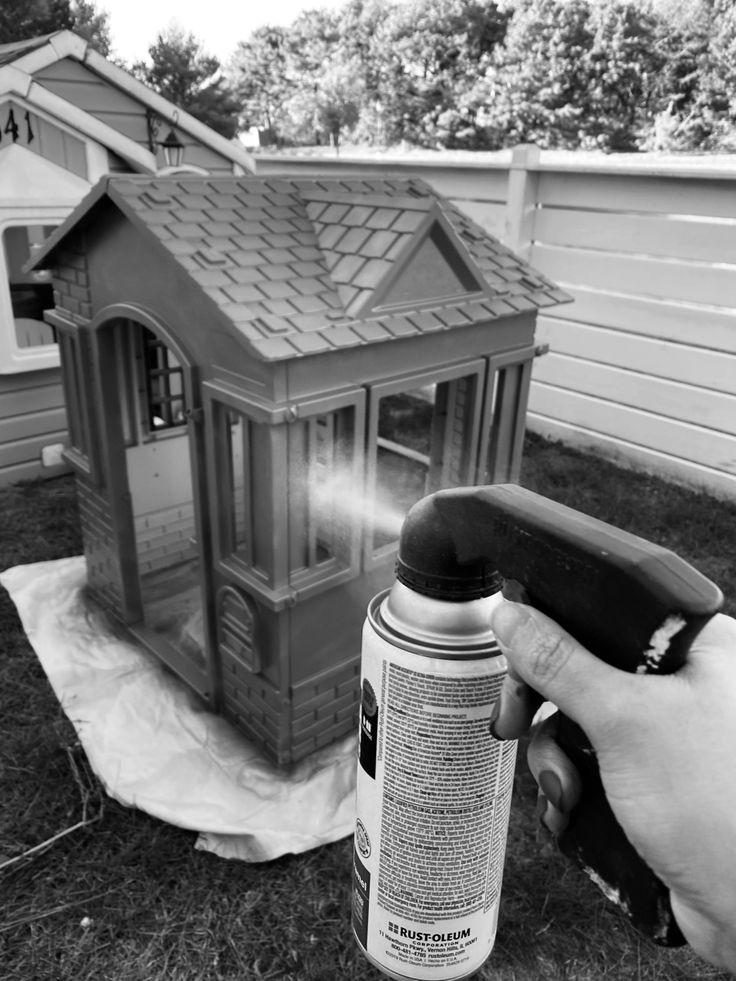 a person spray painting the outside of a house