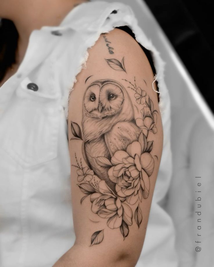 an owl and flowers tattoo on the arm