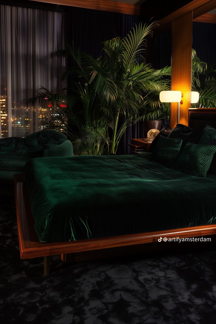 a bed with green sheets and pillows in a room next to a window at night