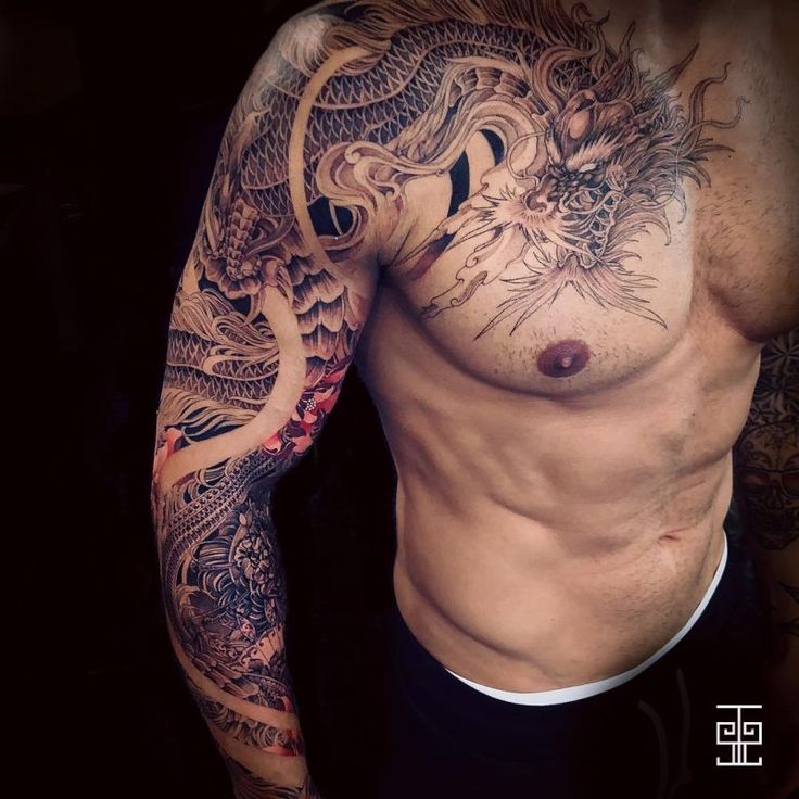 a man with a dragon tattoo on his arm and chest is posing for the camera