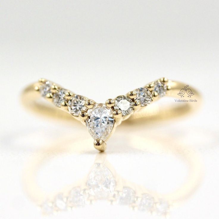 a yellow gold ring with three pear shaped diamonds